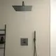Duschbereich mit einer großen modernen Regenbrause von Ideal Standard, Wandmontage, an einer hellen Wand, neben einem Shower-Wandhalter mit Schlauch und Handbrause.